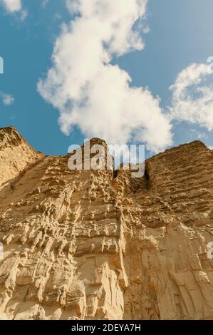 The imposing and eroded sandstone cliffs exposing millions of years of sedimentary geological layers. West Bay in Dorset on the Jurassic coast. Stock Photo