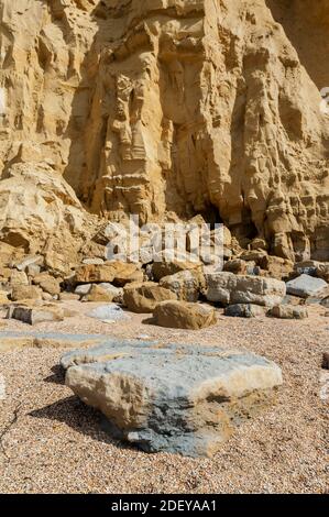 The imposing and eroded sandstone cliffs exposing millions of years of sedimentary geological layers. West Bay in Dorset on the Jurassic coast. Stock Photo