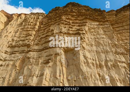 The imposing and eroded sandstone cliffs exposing millions of years of sedimentary geological layers. West Bay in Dorset on the Jurassic coast. Stock Photo