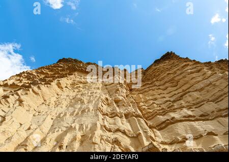 The imposing and eroded sandstone cliffs exposing millions of years of sedimentary geological layers. West Bay in Dorset on the Jurassic coast. Stock Photo