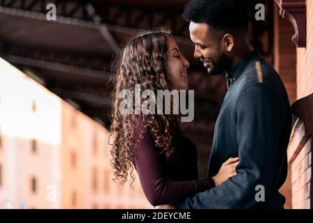 Stock photo of happy moment of interracial couple of lovers having fun in the street. They are in Madrid city Stock Photo