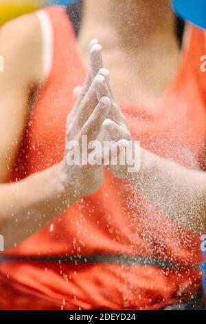 Stock photo of an adult woman chalking her hands before rock climbing. Only her hands are seen, she is unrecognizable. Stock Photo