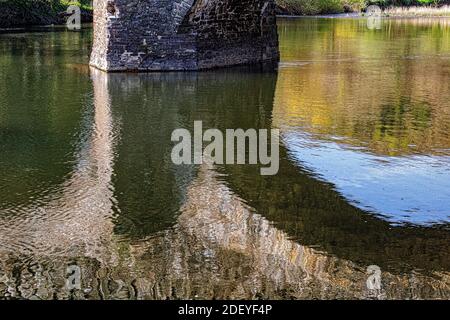 Colourful River Reflections Under the Arches of the Historic Taddiport Bridge on the River Torridge. Stock Photo