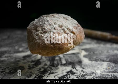 Bread falling or flying on floury black table.Concept of bakery, baking and cooking Stock Photo