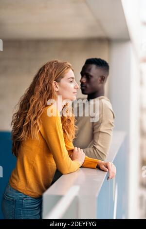 Stock photo of multiethnic couple looking at front and standing. Stock Photo