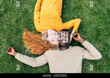 Stock photo of lovely young couple lying in the grass. Stock Photo