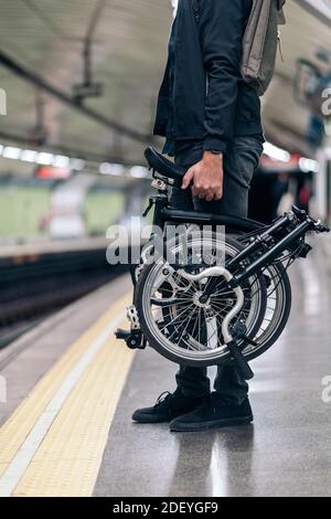 Stock photo of unrecognized man in the metro holding his detachable bike. Stock Photo