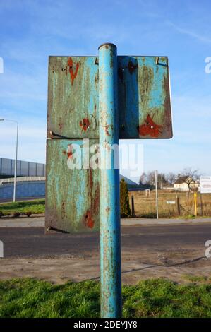 A vertical shot of an old rusty sign on a road Stock Photo