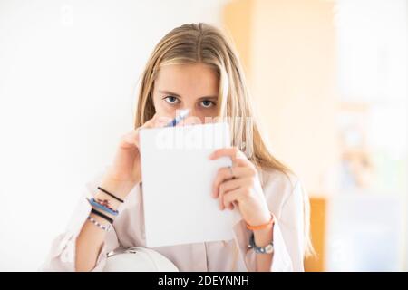 young woman with pencil and folio in an office working Stock Photo