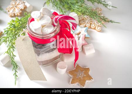 Hot chocolate dry mix in mason jar. Christmas and winter holiday handmade gifts idea. Edible handmade Christmas gift, on white background with Xmas gi Stock Photo