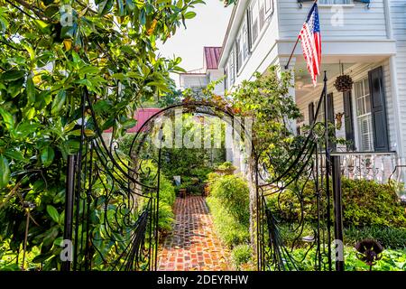Mount Pleasant, USA - May 11, 2018: American residential house building in Charleston, South Carolina area with American flag decoration and gate entr