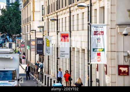 London, UK - June 22, 2018: Above high angle view on pedestrians people walking on street sidewalk and banners signs for restaurants such as Subway Stock Photo