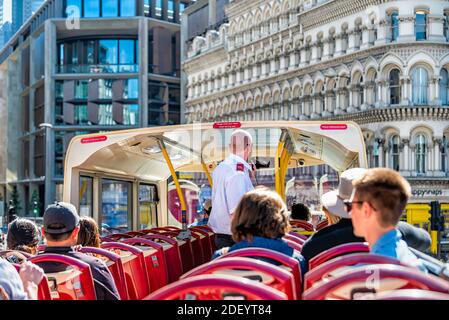 London, UK - June 22, 2018: Downtown city and pov of top of Big Bus double decker with guided tour guide man speaking on microphone and tourists sitti Stock Photo