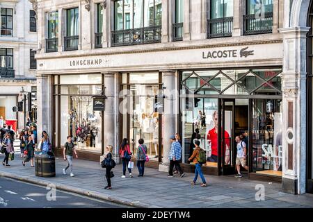 London, UK - June 22, 2018: Storefront sign for Lacoste French clothing clothes boutique store on Regent street road in England with people pedestrian Stock Photo