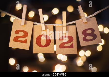 The year 2028 written on pinned cards hanging from a string. Stock Photo