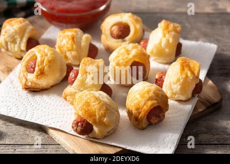 Pigs in blankets. Mini sausages wrapped in puff pastry with ketchup sauce. Stock Photo