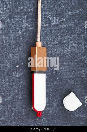 USB flash card is connected with USB cable, gray background. Close-up. Virtual memory with USB output Stock Photo