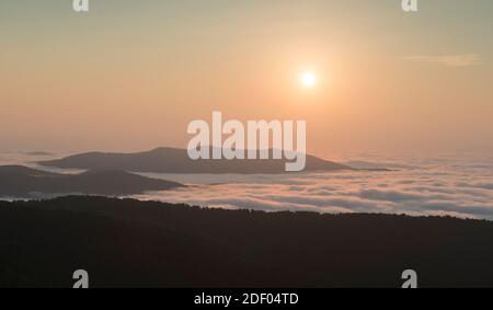 The sunrise burns off early morning fog in the Blue Ridge Mountains, Shenandoah National Park, Virginia. Stock Photo