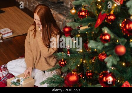 High-angle shot of red-haired woman with emotion of joy and happy during talking on mobile phone