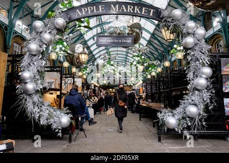 London, UK 2nd December 2020. After a four-week government imposed closure of non-essential retailers craft stall holders in Covent Garden's Apple Market prepare to welcome back customers. Stock Photo