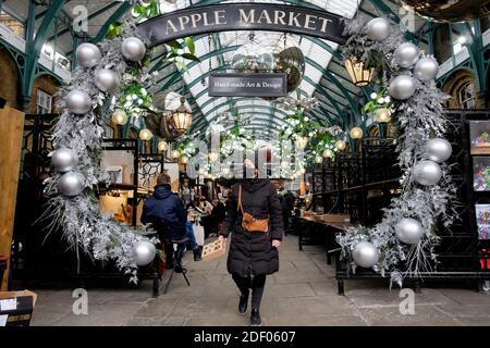London, UK 2nd December 2020. After a four-week government imposed closure of non-essential retailers craft stall holders in Covent Garden's Apple Market prepare to welcome back customers. Stock Photo