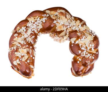 Sweet braided bread in horseshoe shape with sliced almonds isolated on white background. One gold baked plaited cake sprinkled with almonds and sugar. Stock Photo