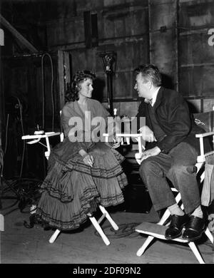 RITA HAYWORTH on set candid with Director CHARLES VIDOR during filming of THE LOVES OF CARMEN director CHARLES VIDOR screenplay Helen Deutsch based on the story by Prosper Merimee producer Charles Vidor executive producer Rita Hayworth The Beckworth Corporation / Columbia Pictures Stock Photo