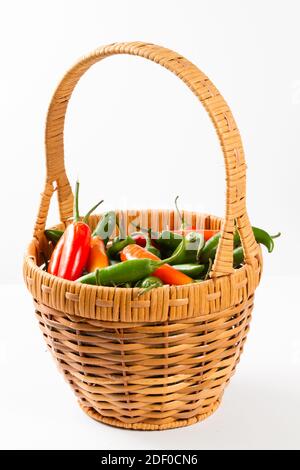Jalapeno peppers in a wicker basket isolated in white background Stock Photo