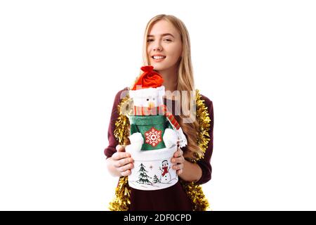 Happy young woman in Santa Claus hat, in hands, a gift box on a white background. Christmas Stock Photo