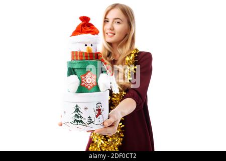 Happy young woman in Santa Claus hat, in hands, a gift box on a white background. Christmas Stock Photo