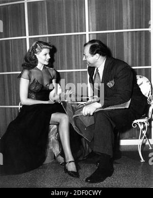 RITA HAYWORTH on set candid with WILLYS of Hollywood during filming of YOU WERE NEVER LOVELIER 1942 director WILLIAM A. SEITER gowns IRENE Columbia Pictures Stock Photo