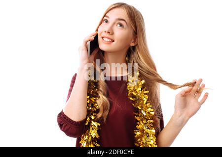 Portrait of a beautiful smiling girl, dressed in a red dress, talking on a mobile phone, standing and looking to the side, isolated on a white backgro Stock Photo