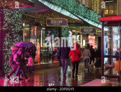 House of Fraser at night during the rain on Oxford Street with people doing their Christmas shopping. London Stock Photo