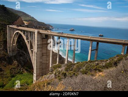 Landscape along the Pacific Coast Highway with cars passing over Bixby Bridge Stock Photo