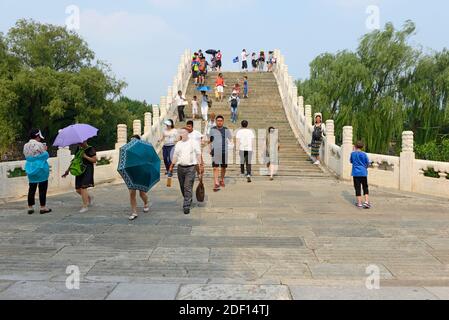 Many visitors cross the humpback Jade Belt bridge, built in the mid 1700s in the Qianlong emperors reign, at the Summer Palace in northwestern Beijing Stock Photo