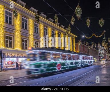 Graz, Austria - November 22, 2019: Santa's tram and beautiful Christmas decorations on famous Herrengasse street, at night, in the city center of Graz Stock Photo