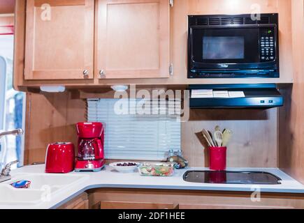 Kitchen in a Recreational Vehicle with Red Appliances for adventure Stock Photo