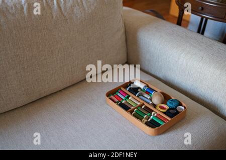 Sewing kit in wooden box on a sofa Stock Photo
