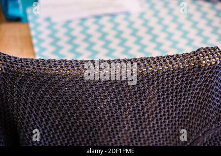 A dark fabric on a chair in front of the carpet with green patterns Stock Photo