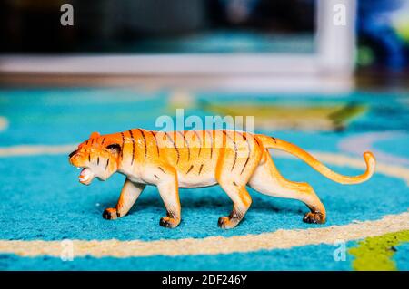 A closeup shot of a tiger figurine on a blue rug Stock Photo