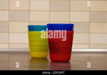 A closeup shot of colorful cups on a wooden table Stock Photo