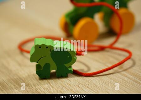 A small wooden frog toy on the wooden floor Stock Photo