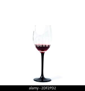 Broken wineglass with remnants of red wine isolated on white background. Stock Photo