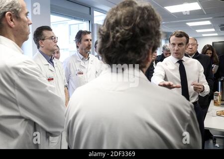 French President Emmanuel Macron, flanked by AP-HP President Martin Hirsch and French Health minister Olivier Veran, meets with medical staff as he visits the Pitie-Salpetriere hospital in Paris on February 27, 2020 where the first French victim of COVID-19 passed away the day before. France has so far registered 18 infections and two deaths, a 60 years-old French citizen and a 80 years old Chinese tourist, as European governments scramble to contain a slew of new coronavirus cases popping up across the continent. Photo by Stephane Lemouton/ABACAPRESS.COM Stock Photo