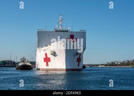 In this photo released by the United States Navy, the Military Sealift Command hospital ship USNS Mercy (T-AH 19) arrives in Los Angeles, California, March 27, 2020. Mercy deployed in support of the nation’s COVID-19 response efforts, and will serve as a referral hospital for non-COVID-19 patients currently admitted to shore-based hospitals. This allows shore base hospitals to focus their efforts on COVID-19 cases. One of the Department of Defense’s missions is Defense Support of Civil Authorities. DoD is supporting the Federal Emergency Management Agency, the lead federal agency, as well as s Stock Photo