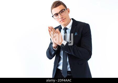A business guy in glasses and a suit, rubbing his hands, a cunning handsome plans his cunning plan on a white background. Stock Photo