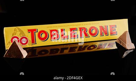 Chocolate Tobleron in packaging on a black background with reflection. Stock Photo