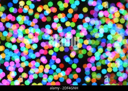 Christmas background, garland in blur. Glowing and festive colored light circles created in camera and bokeh lens. Christmas fairy lights are defocuse Stock Photo