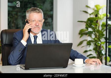 Angry entrepreneur talking on phone Stock Photo