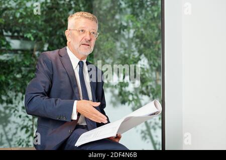 Portrait of senior head engineer with construction plan in hands talking to coworker Stock Photo